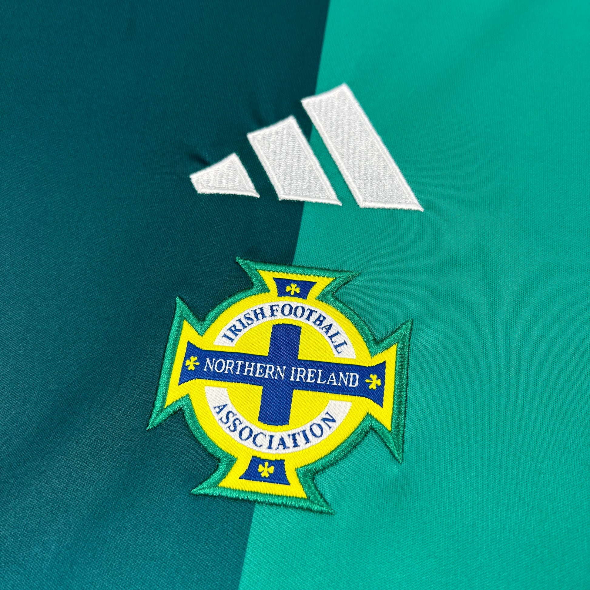 Close-up of Adidas Northern Ireland 2026 Home Jersey jersey with Adidas logo and Northern Ireland Association emblem.