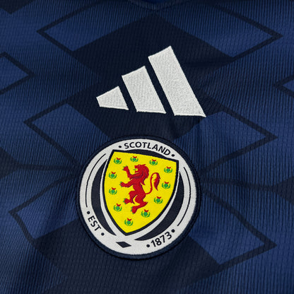 Scotland national team logo on a blue background with Adidas logo above on the Adidas Scotland 2026 World Cup Home Jersey.