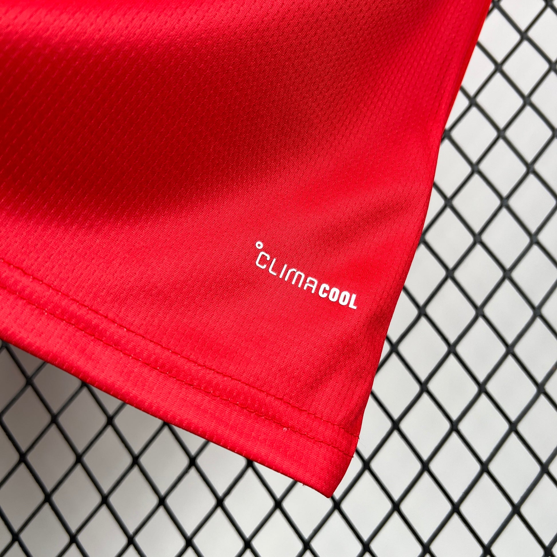 Red Adidas Wales 2026 World Cup Home Jersey with 'ClimaCool' logo against a wire mesh background