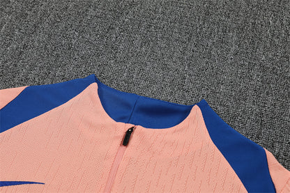 Close-up of the pink quarter-zip top showing zipper detail.