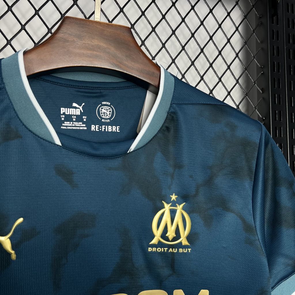 A close up view to the front of Olympique Marseille's 24/25 Away Blue Jersey.