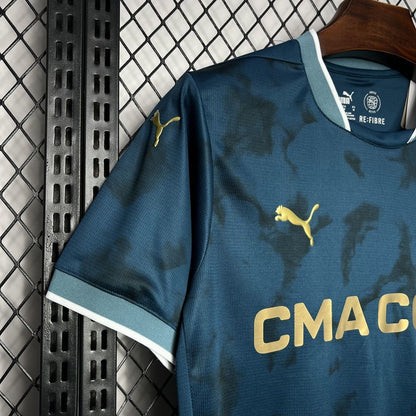 Top side view of the Olympique Marseille 24/25 Away Blue Jersey, puma logo in gold.