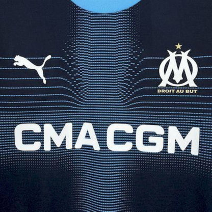 Close-up of Olympique Marseille 25/26 Away Blue sports jersey with Puma and Olympique de Marseille logos.