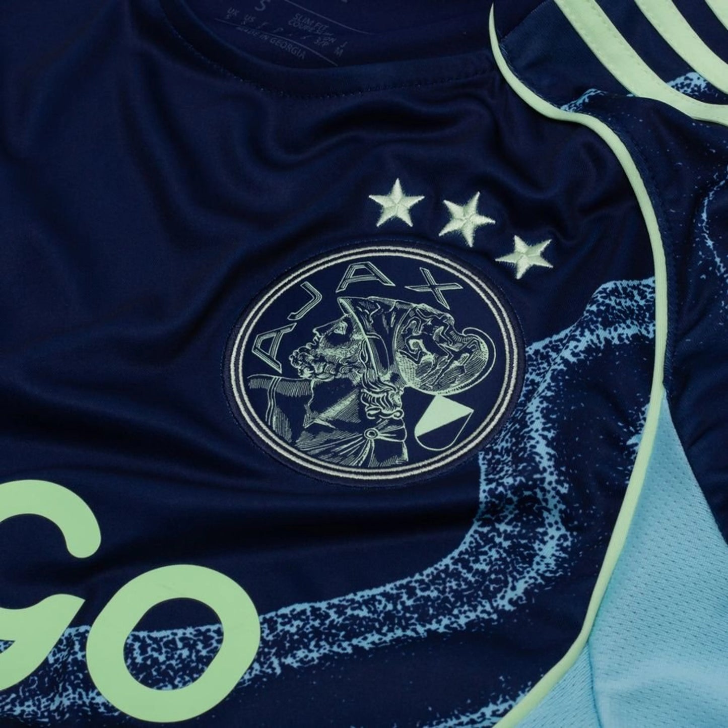 team logo view on the adidas Ajax 2025/26 Away Blue Shirt