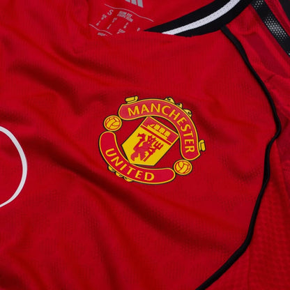 team logo view of the adidas logo view on the Manchester United 2025/26 Home Red Jersey